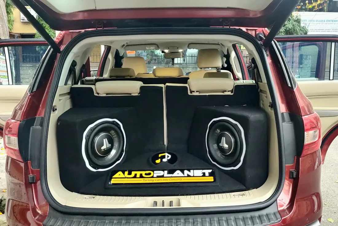 A red MPV boot with two JL Audio subwoofers set into a fabricated panel