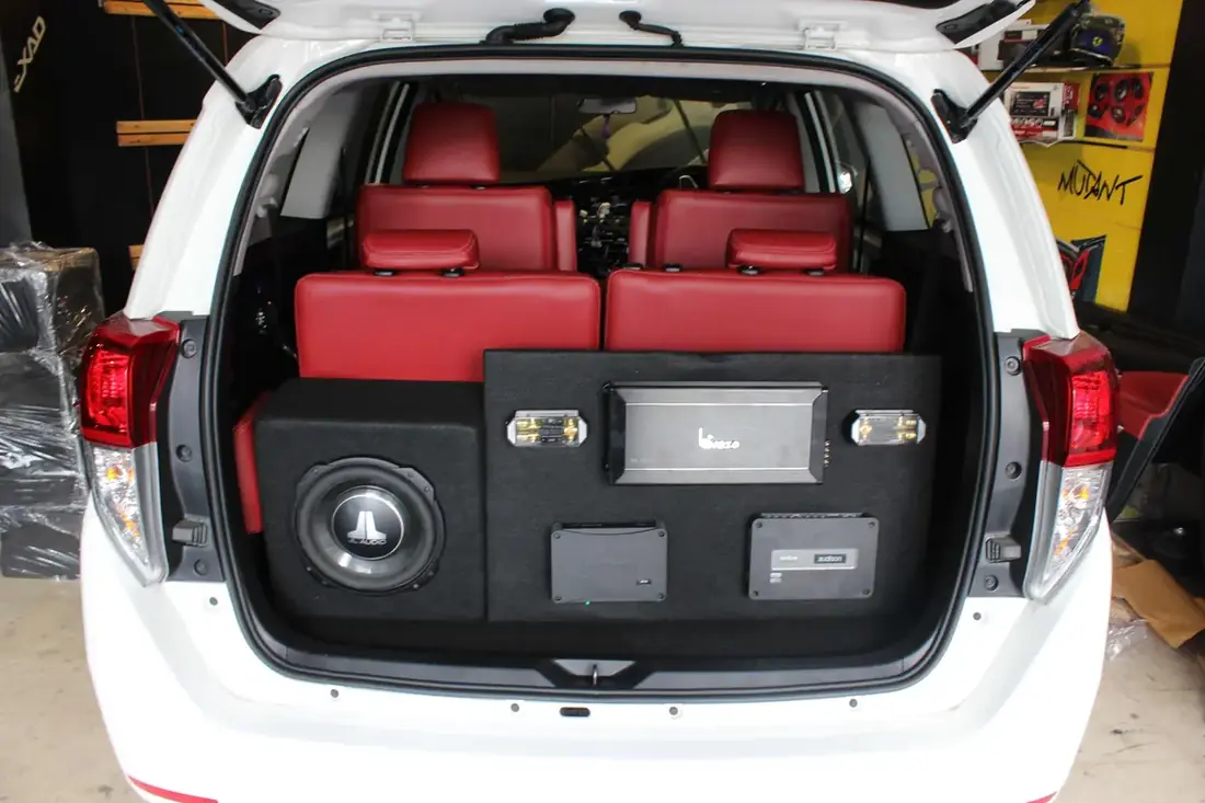 An MPV boot with a subwoofer and amplifiers built into the floor panel, red leather seats behind